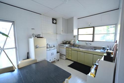 Fukuoka - House - Vacation STAY 4674 في فوكوكا: مطبخ فيه ثلاجة وطاولة