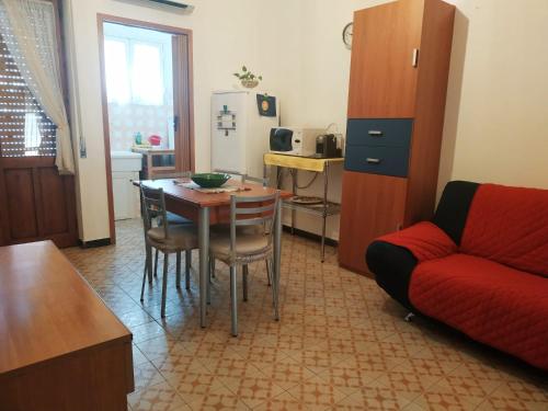 ein Wohnzimmer mit einem Tisch und einem roten Sofa in der Unterkunft Casa Poggio in Cagliari