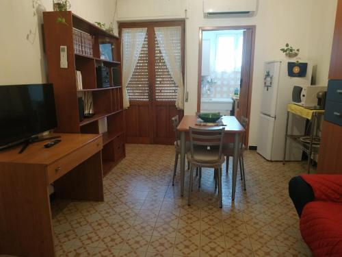 eine Küche mit einem Tisch und Stühlen sowie einem Kühlschrank in der Unterkunft Casa Poggio in Cagliari