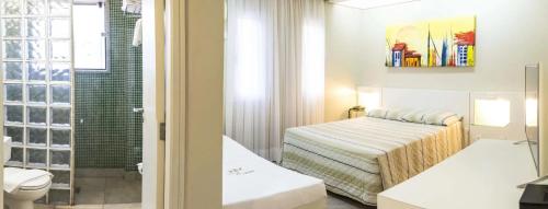 a bathroom with a bed and a toilet in a room at VOA Plazza Hotel in Águas de Lindóia