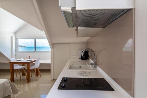 a kitchen with a sink and a stove top oven at Sweet Home SXM Baie Nettlé Pieds dans l'eau in Saint Martin