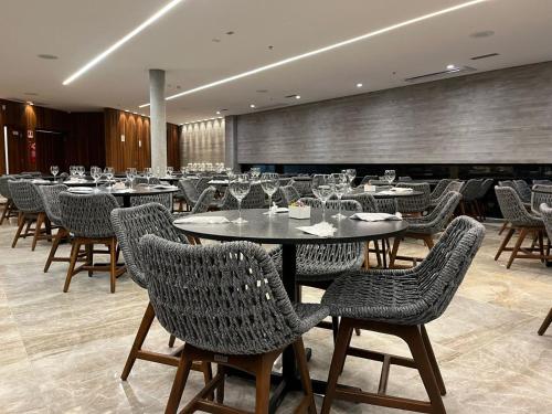 a restaurant with tables and chairs with wine glasses at Salinas Premium Resort in Salinópolis