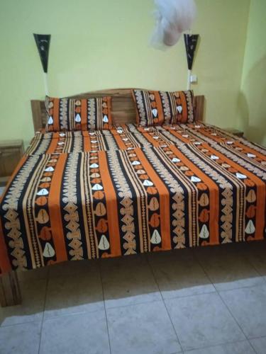 a large bed with a bunch of blankets on it at Auberge Africa Thiossane in Saly Portudal