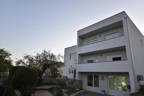 a white building with a lot of windows at Apartmani JURIĆ in Međugorje
