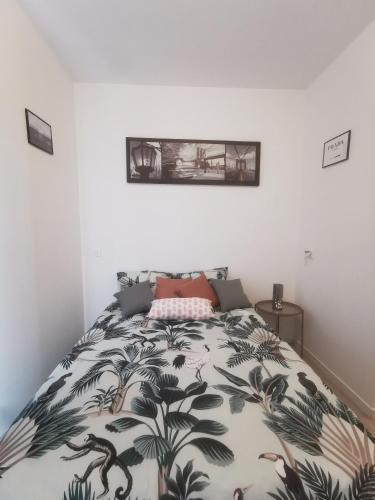 une chambre avec un lit avec un couvre-lit fleuri dans l'établissement Appartement cozy en plein centre ville, à Amiens