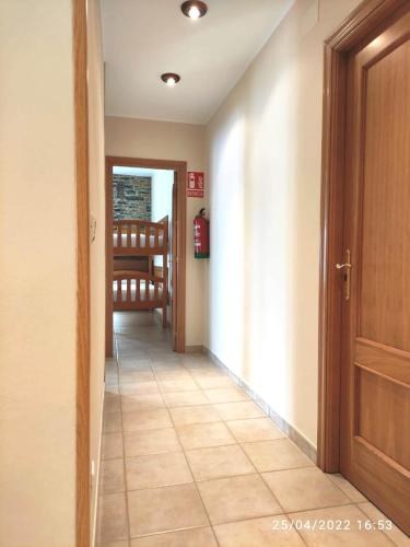 a hallway with a door and a tiled floor at Apartamento Campomanes in Villaviciosa