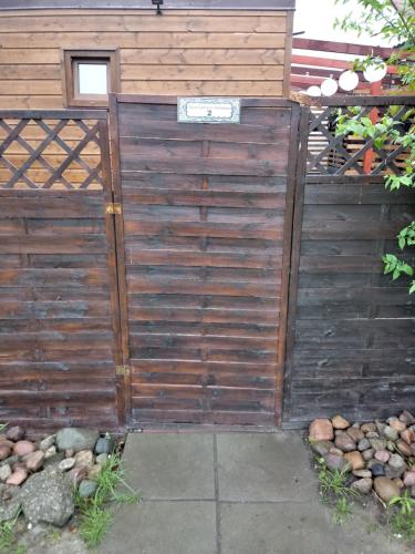 a wooden privacy fence next to a building at Apartament Antonio 2 Gdańsk in Gdańsk