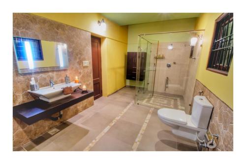 a bathroom with a toilet and a sink and a shower at Costa Verde Luxury Seafront Villa in Chennai