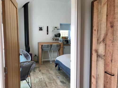 a room with a bed and a kitchen with a table at The Bothy - your unique luxury refuge in Saint Fillans