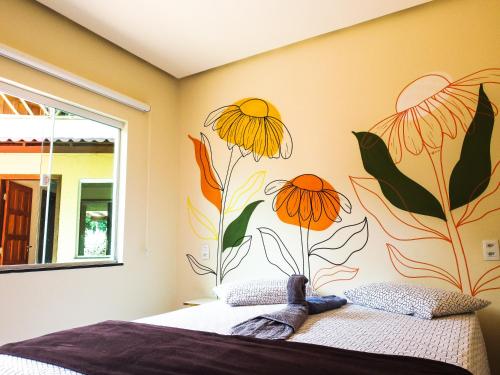 a bedroom with a mural of orange flowers on the wall at Chalé Ribeirão do Meio in Lençóis