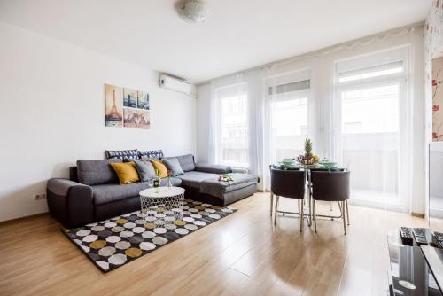 uma sala de estar com um sofá e uma mesa em Grand Budapest Penthouse em Budapeste