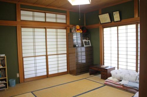 Zimmer mit 3 Türen und einem Tisch in einem Zimmer in der Unterkunft Minpaku Taki - Vacation STAY 12840 in Gero