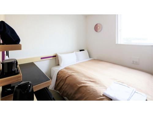 a small bedroom with a bed and a desk and a window at Center Hotel Narita 2 R51 - Vacation STAY 43395v in Narita