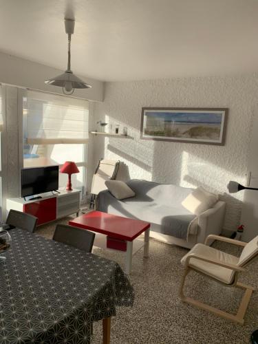 Cet appartement comprend une chambre avec un lit et un salon avec une table. dans l'établissement Petite escapade à la Picardière, à Fort-Mahon-Plage