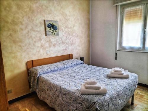 a bedroom with a bed with two towels on it at B&B Hotel Costa Azzurra in Spotorno