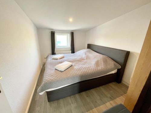 ein kleines Schlafzimmer mit einem Bett mit zwei Handtüchern darauf in der Unterkunft Komfortables Apartment nahe Hafen in Wismar