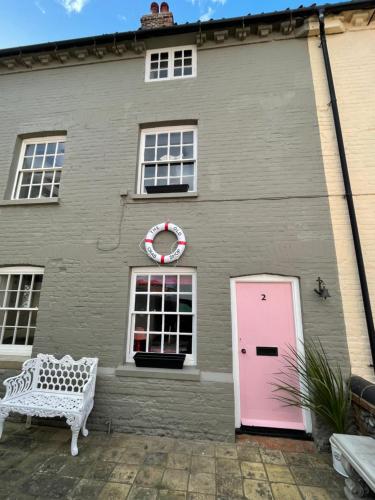 a pink door on the side of a house at The Old Crab Shop. PERFECT location & sea views. in Cromer