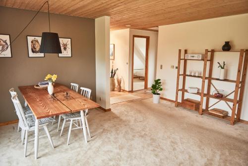 a dining room with a wooden table and chairs at Stylish vacation home - close to sea and nature in Hejls