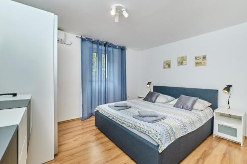 a bedroom with a bed in a room with a window at Apartments Hemetek in Veli Lošinj