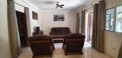 sala de estar con sofá, mesa y sillas en The Rink Apartment's en Sukuta