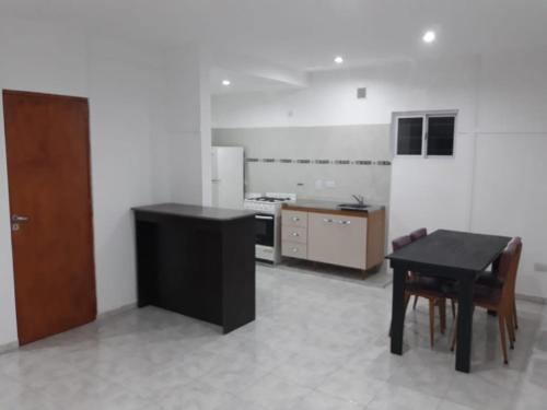 a kitchen with a black table and a table and chairs at El mejor descanso in Plottier