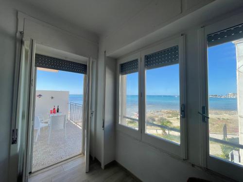 Zimmer mit Fenstern und Meerblick in der Unterkunft Viva Vista Mare Trilo Primo Piano in Porto Cesareo