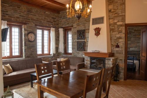 - un salon avec une table et une cheminée dans l'établissement Notas Pelion Seaview Villa, à Zagora