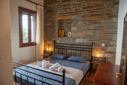 - une chambre avec un lit et un mur en pierre dans l'établissement Notas Pelion Seaview Villa, à Zagora