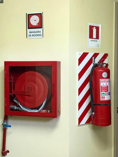 a fire hydrant and a red microwave on a wall at Juku Hostal in Calama