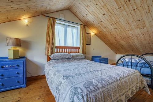 een slaapkamer met een bed met een blauw dressoir en een raam bij North West Sea View No 3 in Yarmouth