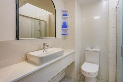 een badkamer met een wastafel, een toilet en een spiegel bij North West Sea View No 3 in Yarmouth