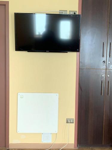 a flat screen tv hanging on a wall at Juku Hostal in Calama