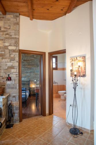 a living room with a stone wall and a fireplace at Notas Pelion Seaview Villa in Zagora