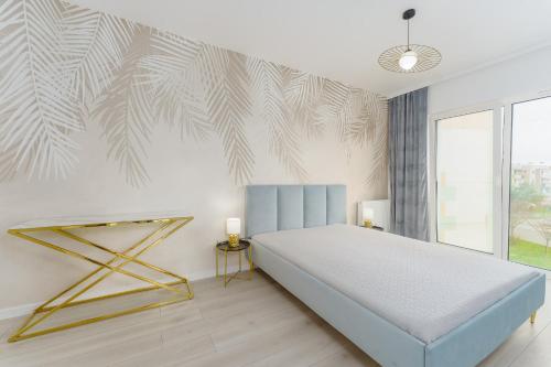 sypialnia z łóżkiem i ścianą z malowidłem w obiekcie Fredry 2 Apartament Liliowy w Kołobrzegu