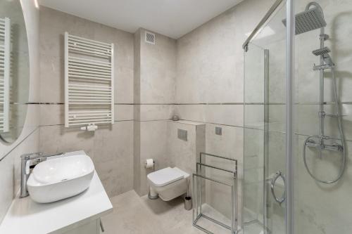łazienka z prysznicem, toaletą i umywalką w obiekcie Fredry 2 Apartament Liliowy w Kołobrzegu