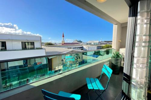 a balcony with chairs and a view of a building at Moana Studio - downtown Papeete - WiFi AC Netflix parking - 3 people in Papeete