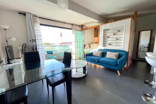 un salon avec un canapé bleu et une table en verre dans l'établissement Moana Studio - downtown Papeete - WiFi AC Netflix parking - 3 people, à Papeete