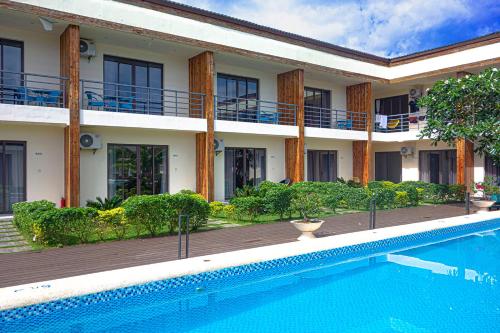 a hotel with a swimming pool in front of a building at Amphitrite Resort in Panglao