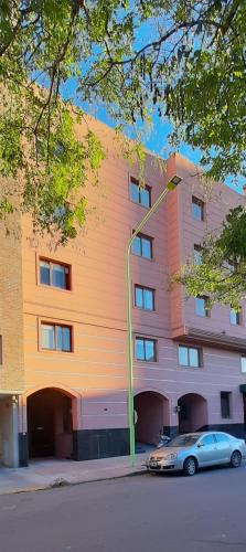 a building with a car parked in front of it at DEPTOS BAHIA in Bahía Blanca