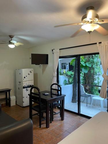 a living room with a table and chairs and a tv at Moonshine Hotel in Playa del Carmen