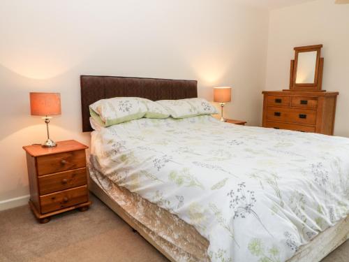 a bedroom with a bed and two night stands and two lamps at Sunnymead Cottage in Halwill