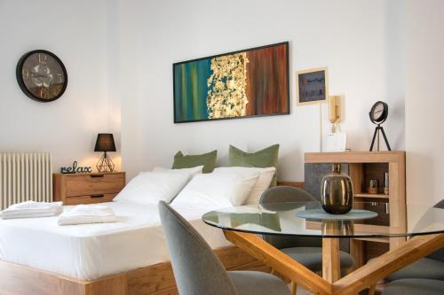 - une chambre avec un lit et une table en verre dans l'établissement Anesis Residence, à Héraklion