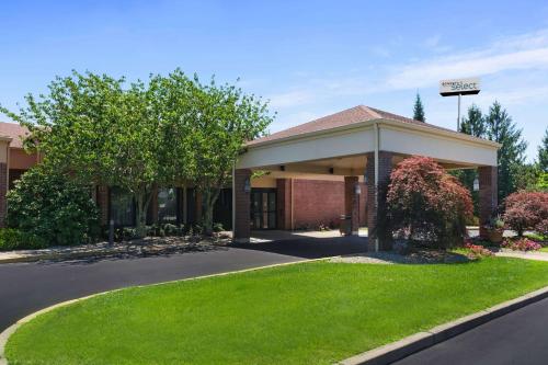 a building with a green lawn in front of it at Sonesta Select Newport Middletown in Middletown