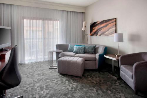 a living room with a couch and a tv at Sonesta Select Newport Middletown in Middletown