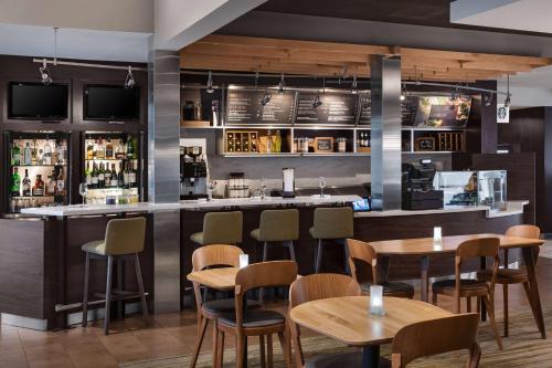 a bar in a restaurant with tables and chairs at Sonesta Select Newport Middletown in Middletown