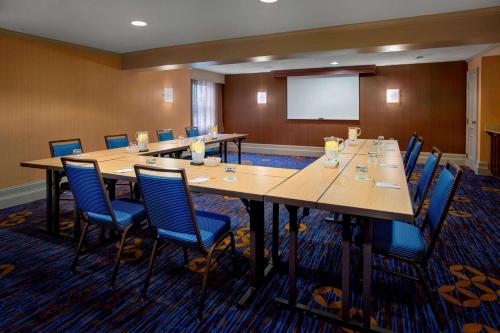 a conference room with tables and chairs and a projection screen at Sonesta Select Boston Danvers in Danvers