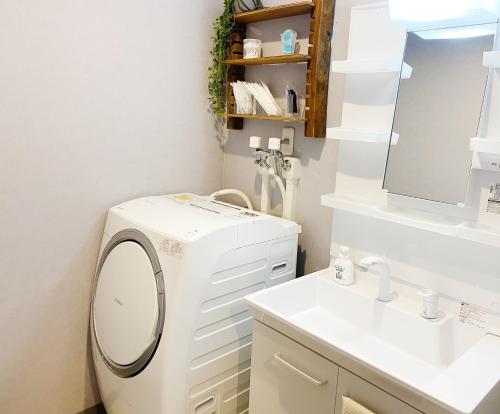 a bathroom with a washing machine and a sink at House COCOA in Hakodate