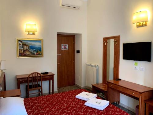 ein Hotelzimmer mit einem Bett, einem Schreibtisch und einem TV in der Unterkunft Paramount in Rom