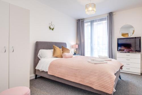 a bedroom with a large bed with a tv on it at Fairytale 2 Bedroom Apartment City Centre Free Parking in Birmingham
