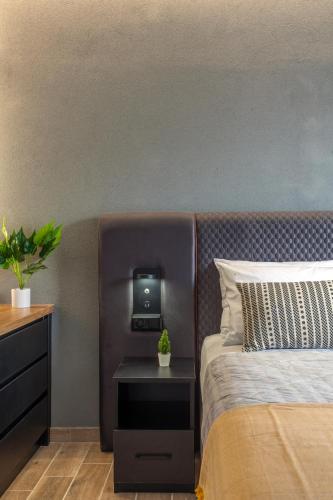 a bedroom with a bed and a tv on a wall at Raise Kornarou City Stay in Heraklio Town